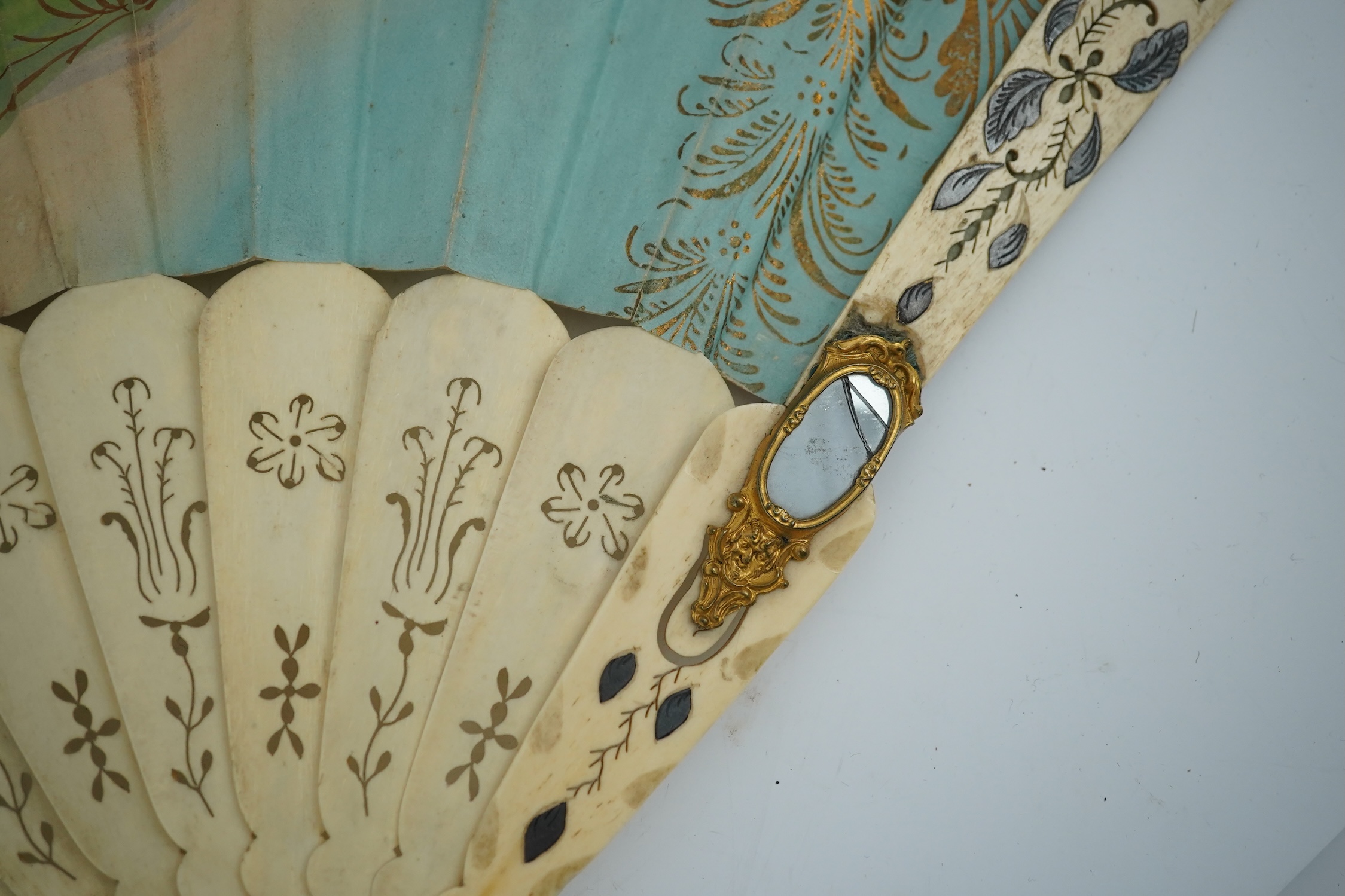 Three French fans: a mother of pearl and sequin fan boxed, a painted silk, feather and bone fan and a gilt decorated bone figural paper fan, the two bone fans having gilt mirrored mounts on the guards, figural paper fan